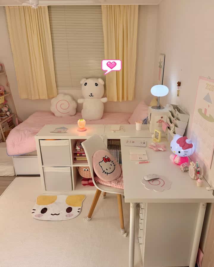 パステルピンクとホワイトのトーンが特徴の子供部屋、ベッドとイケアのデスク、ラグが配置された雰囲気のあるインテリア