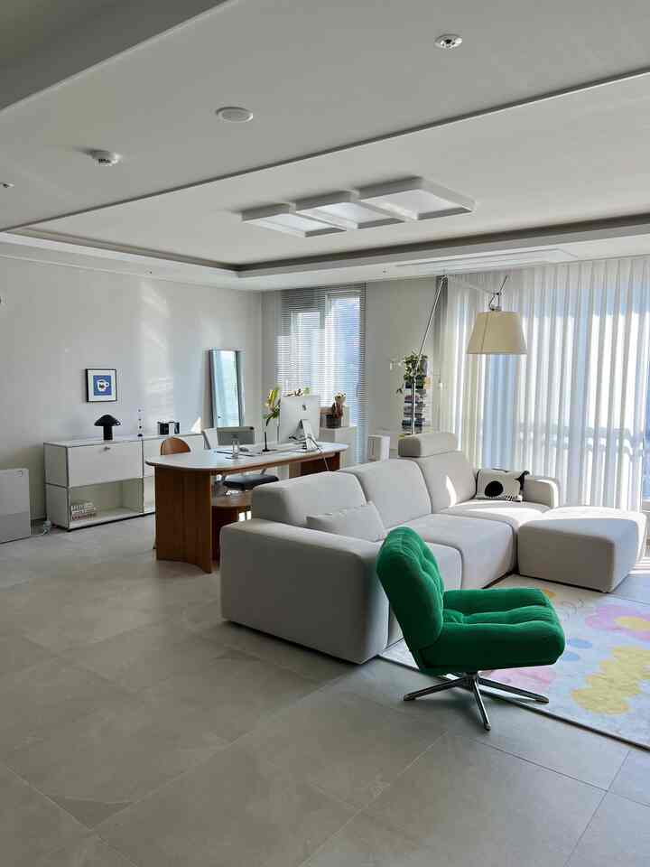 白と緑の調和が美しいリビング、モジュラーソファとダイニングテーブル、USMサイドボードが配置された明るく清潔感のあるインテリア