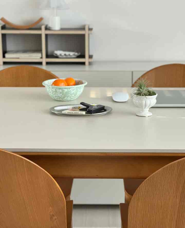 ホワイトとナチュラルな木目調のカフェ風ダイニングルーム、清潔なダイニングテーブルと木製チェアが配置された落ち着いた空間