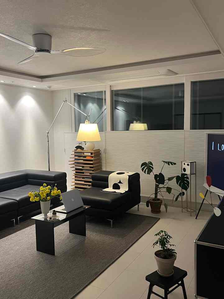 Modern living room featuring black leather sofa and white walls, creating a clean and comfortable atmosphere