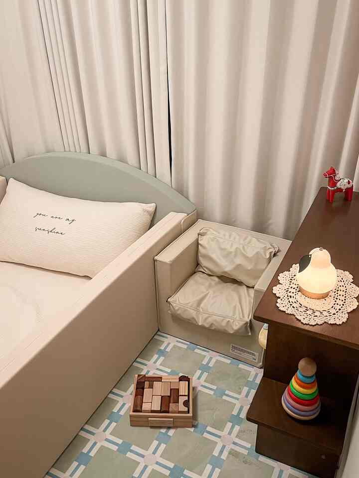 柔らかいベージュ調の赤ちゃんの部屋、木製のおもちゃとクッションが配置された温かみのあるインテリア