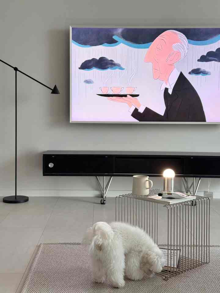 ホワイトとブラックのトーンのリビング、中央に犬とスチール製のサイドテーブル、左にモダンなフロアランプが配置された清潔感のある空間