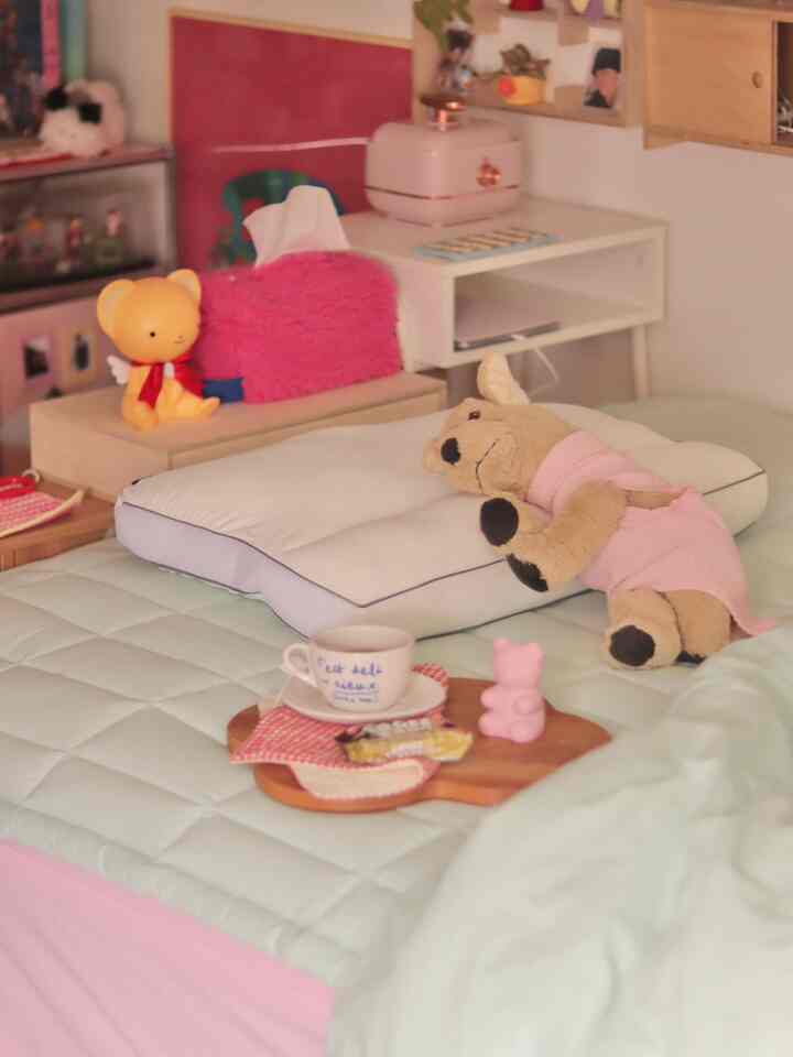 パステル調の寝室、柔らかな寝具と赤ちゃんのぬいぐるみが配置された温かみのある空間