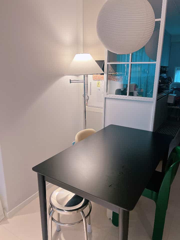 ホワイトとブラックのトーンのコンパクトなダイニングルーム、黒いダイニングテーブルとさまざまなチェアが配置された印象的な空間