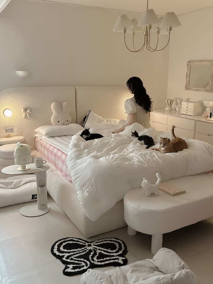 ホワイトトーンの寝室、ふわふわのベッドとラグ、複数の猫がいるペットフレンドリーな居心地の良い空間