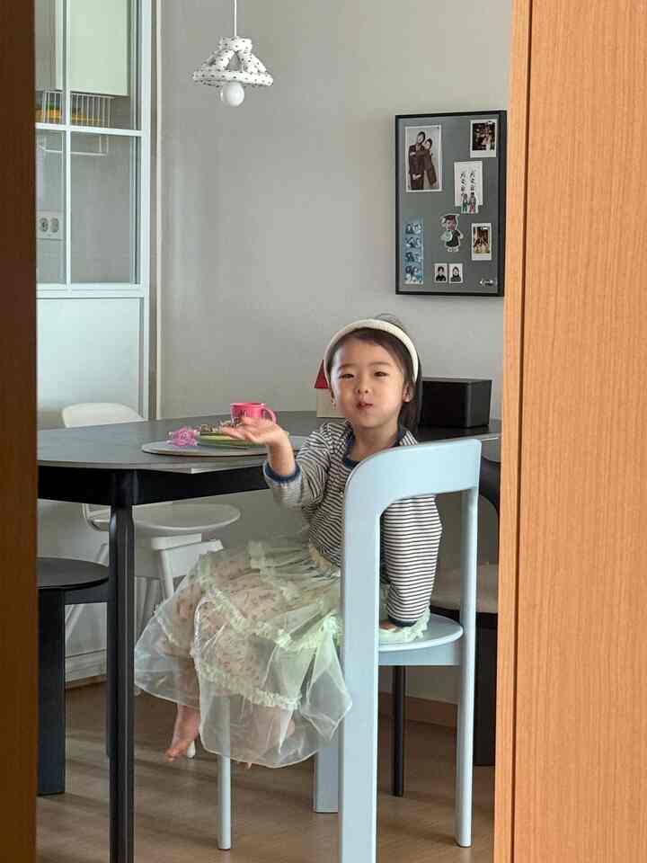 ナチュラルな木目調とベージュの色調が調和するダイニングルーム、シンプルな空間に子供が椅子に座っているインテリア
