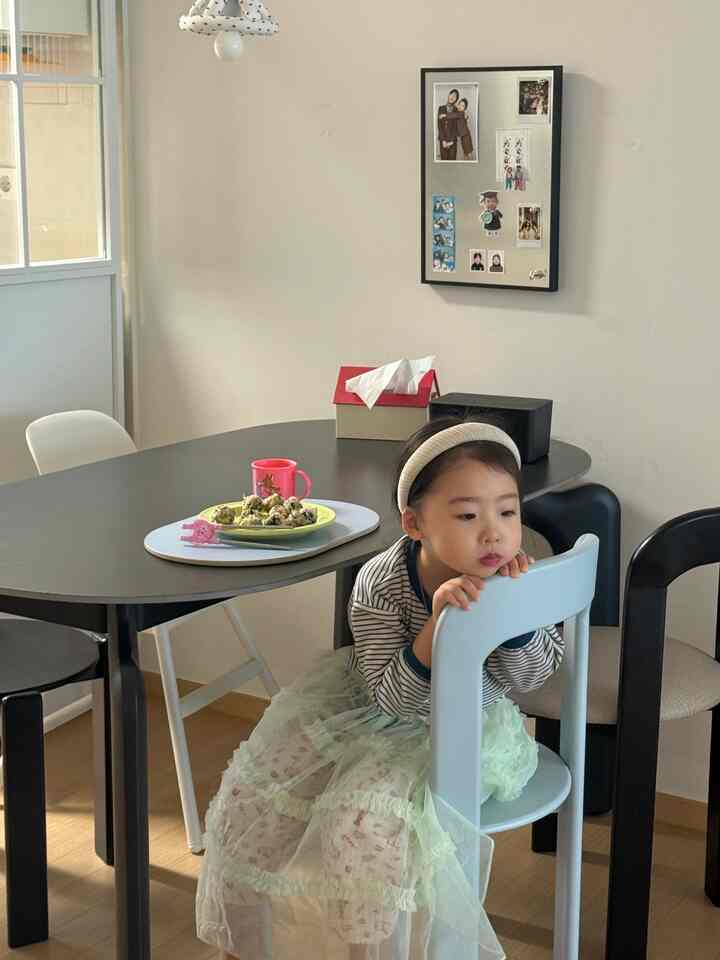 ベージュの壁と黒いダイニングテーブル、ダイニングチェアが配置された子供と暮らすファミリーダイニングの雰囲気あるおうちカフェ空間