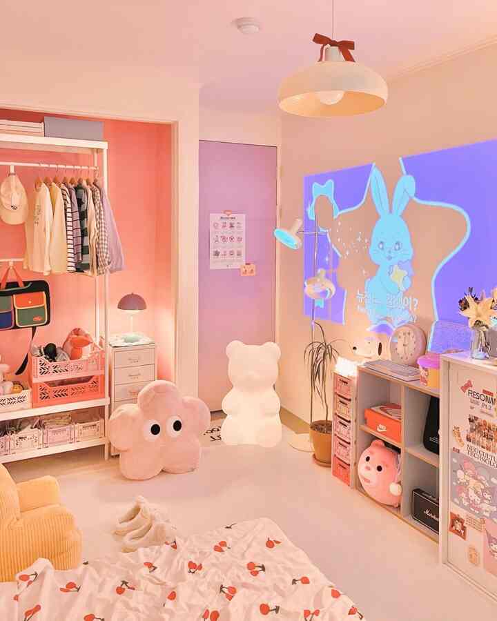 ピンクと白の色調のコンパクトな子供部屋、オープンクローゼットやぬいぐるみ、温かみのある照明が配置された印象的な空間