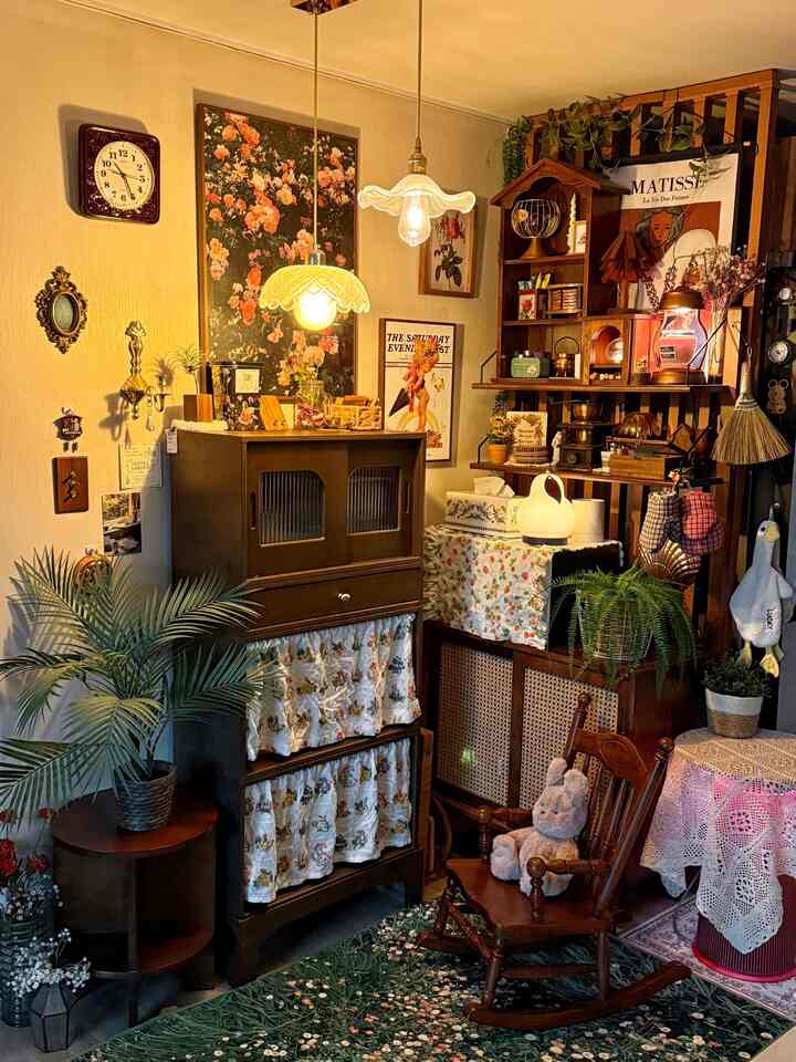 暖かいベージュの壁と木製家具が調和したヴィンテージスタイルのリビング、花柄のラグとペンダントライトが特徴的な空間