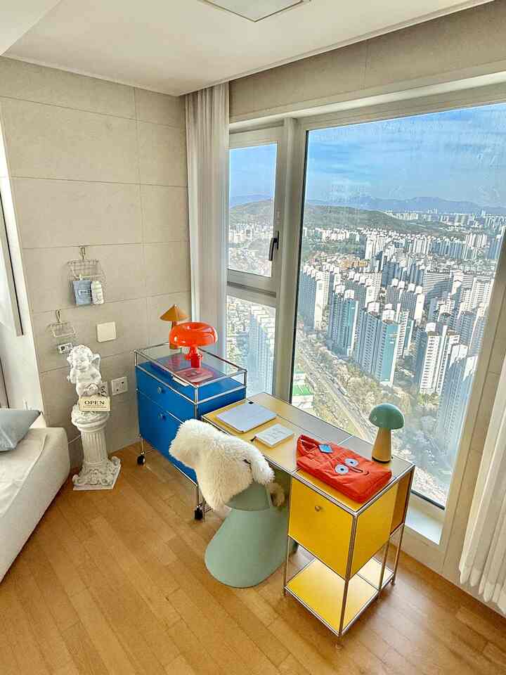 ホワイトとブルー、イエローのトーンのコンパクトなホームオフィス、机とキャビネットが配置された明るく実用的なインテリア