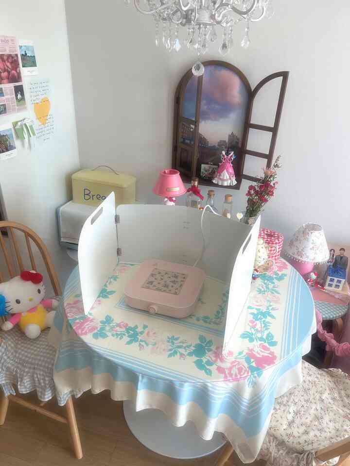 白とピンクの色調が印象的なホームカフェ風ダイニングスペース、花柄のテーブルクロスとアーチ型の装飾が配された雰囲気のあるインテリア