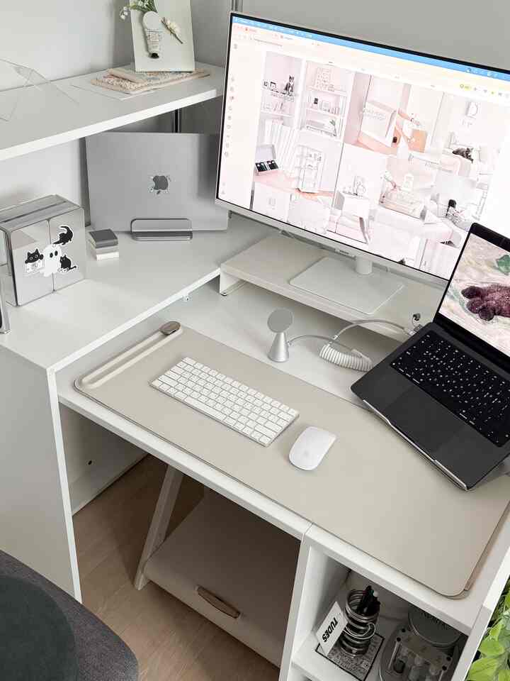 白を基調とした清潔感のあるホームオフィス空間、デスクとモニタースタンドが配置され、実用的でモダンな在宅勤務環境
