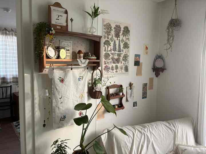 ナチュラルな色調のリビング、ホワイトソファと木製棚、植物が配置された雰囲気のある空間