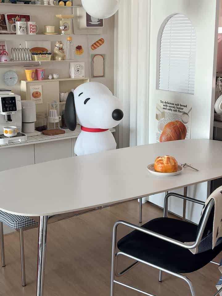白を基調としたキッチンとダイニングスペース、かわいいスヌーピーの装飾と清潔感のある居心地のよいインテリア