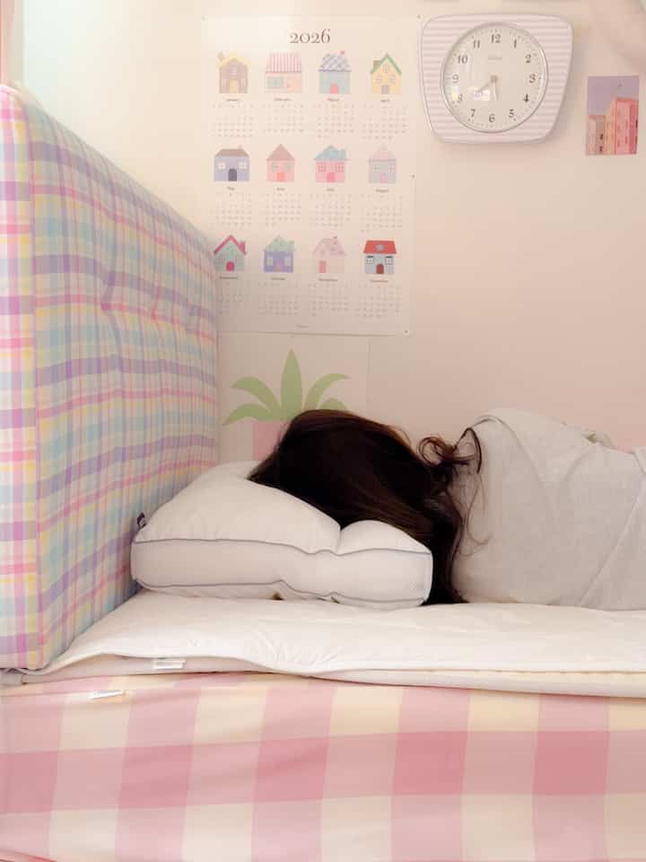 Pink and white toned bedroom featuring pillow and bedspread in a cozy setting