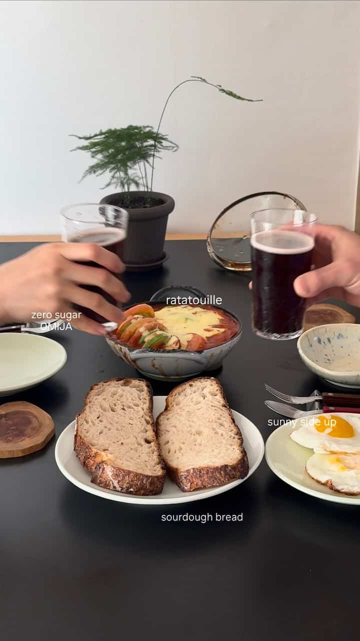 モダンな雰囲気の黒いダイニングテーブルと白い料理が配置されたキッチンスペース