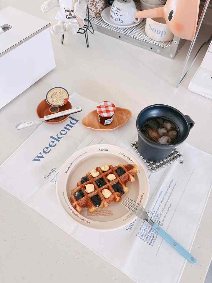 明るい白色のトーンが特徴的なキッチン空間、ワッフルとアイスコーヒーが配されたカフェ風のテーブルセット