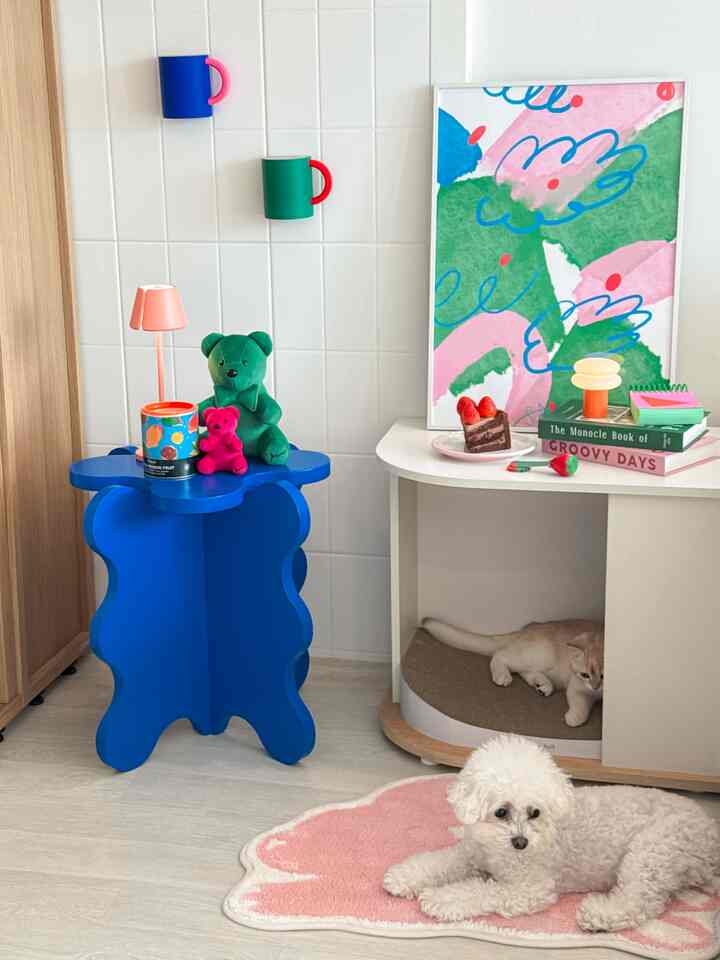 青と緑の色調の子供部屋、青い雲形スツール、テディベア、キャットハウスが配されたシンプルでナチュラルなインテリア