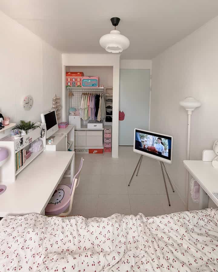 白を基調とした狭い子供部屋、机やハンガー、ベッドが配置された清潔感のある雰囲気のインテリア