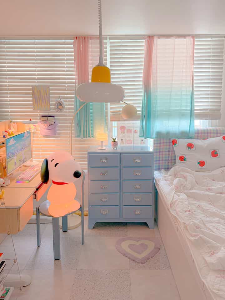 白とパステル調の子供部屋、子供用デスクと光るスヌーピーランプが配置された雰囲気のある空間