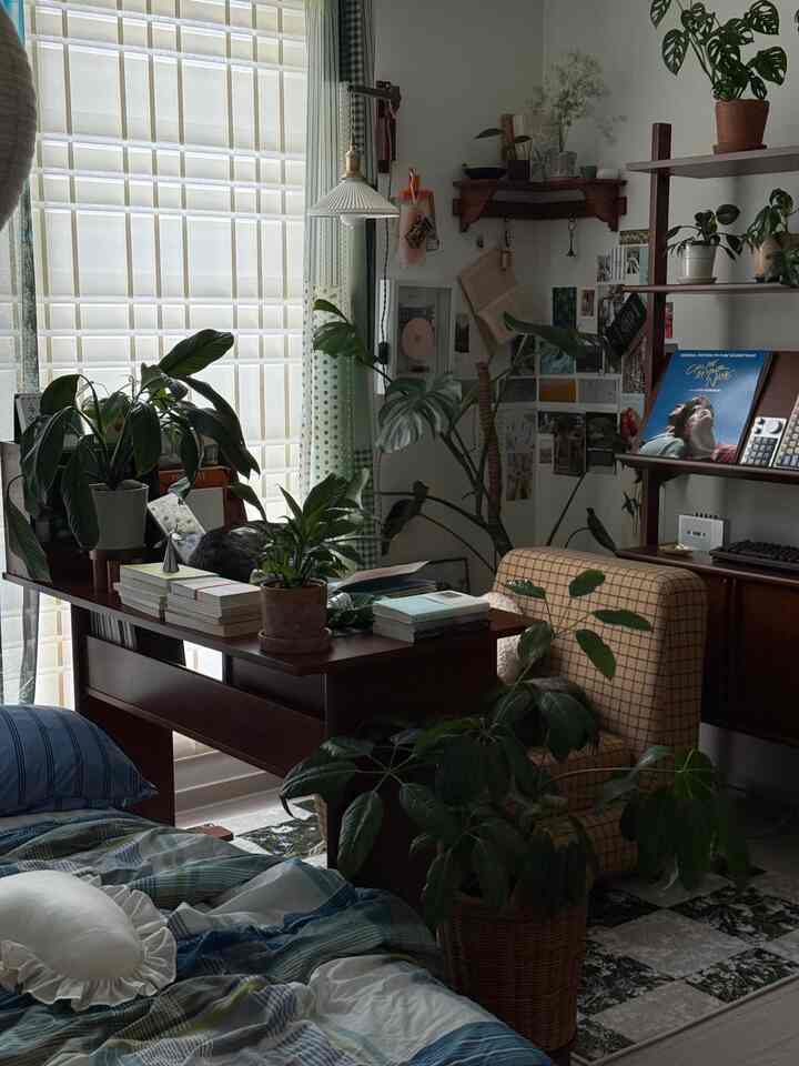 ナチュラルカラーの小さなリビングルーム、デスクとアームチェア、植物が調和した落ち着いたホームオフィスのインテリア