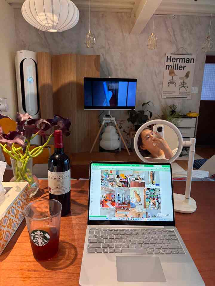 ナチュラルな色調と北欧風のリビング、ワインボトルとテーブルミラーが配置された雰囲気のある空間