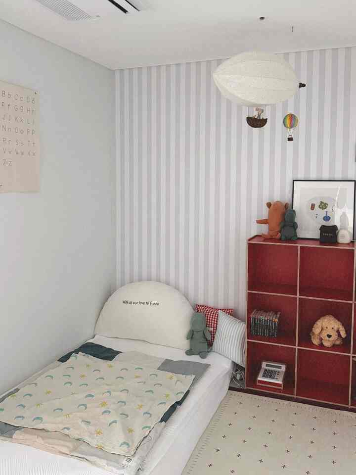 ホワイトトーンの子供部屋、シンプルでナチュラルモダンな雰囲気に赤い本棚がアクセントの空間