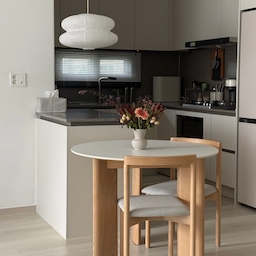 #오감리뷰 셀렉션 프로그램을 통해 제품을 제공받아 
직접 사용하고 스타일링한 후기입니다.
저의 로망 •• 원형테이블이 도착했어요!
주방이 작은 편이라서 크고 각진 식탁이 
답답해 보인다고 생각했고 전형적인 K아파트 주방에
새로운 분위기를 더해주고 싶었거든요 😖
1000사이즈 원형 식탁이라 
공간이 한층 넓고 가볍게 느껴지는데 동선도 편하고
남편이랑 더 가까이 마주 앉을 수 있어서 마음에 들었어요
사이즈를 보니 1-4인 가구가 사용하기 좋은 것 같아요..!
거실이 블랙 인테리어라서 
식탁은 미드내추럴 컬러로 골랐는데요
실제로 보니까 더 예뻐요♥ 원목 다리 덕분에 
전체적으로 따뜻한 분위기가 나면서도
밝은 세라믹 상판이 더해져 
무겁거나 올드해 보이지 않고 깔끔하더라고요
식탁 편하게 쓰려면 상판은 세라믹이 좋은거 아시나요~?
12T 통세라믹이라 내구성도 좋고 관리가 정말 편합니다
음식이나 소스가 묻어도 크게 신경 쓸 필요 없이
슥- 닦아내면 되니까 매일 부담 없이 사용할 수 있거든요 
그래서 원목 식탁을 갖고 싶지만 관리 때문에 
고민하시는 분들이 좋아하실 것 같아요!
식탁 다리는 약간 볼드하게 쭉 뻗어 있어서 
안정감 있으면서 시원해 보이고 같이 둔 의자는 
라인이 슬림해서 식탁이랑 조합이 좋았어요!
의자 자체가 가벼워서 청소하거나 옮길 때도 편하고요 
방석도 푹신해요 𓂅𓂅︎︎︎︎︎︎︎︎︎︎︎︎︎︎
어떤가요 저희집 식탁 저는 너무 마음에 드는데요 ..🖤
원형 식탁 찾고 계신다면 한 번 둘러보세요!
#원형식탁 #원형테이블 #원형테이블1000 #식탁
#원형식탁1000 #주방 #주방인테리어 #주방꾸미기 
#주방식탁 #주방식탁추천 #주방식탁의자 
#25평인테리어 #25평주방 #25평아파트 #타워형
#타워형주방 #타워형아파트 #타워형인테리어 
#오늘의집 #오늘의집레이어 #신혼가구 #신혼집가구
