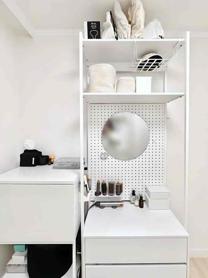 白を基調としたコンパクトなウォークインクローゼット、化粧台と収納が整然と配置された雰囲気のあるインテリア