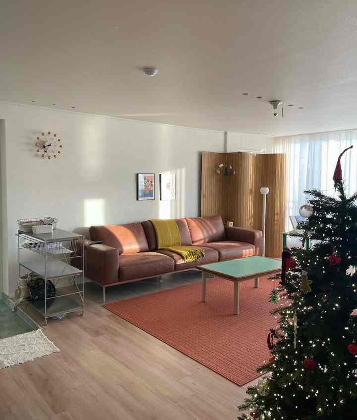 ブラウンとベージュの色調のリビング、レザーソファとコーヒーテーブルが配置された温かみのある空間