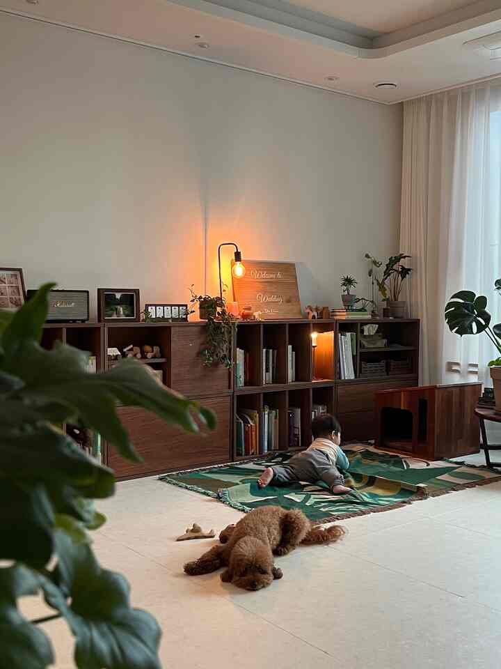 ナチュラルブラウン調のリビング、木製の本棚と赤ちゃん、犬がくつろぐ暖かなインテリア