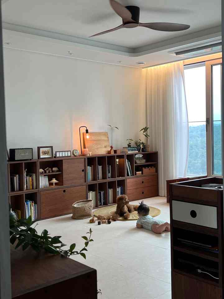 ナチュラルな色調のリビング、モダンな木製収納キャビネットとラグの上に赤ちゃんと犬がいる雰囲気のあるインテリア