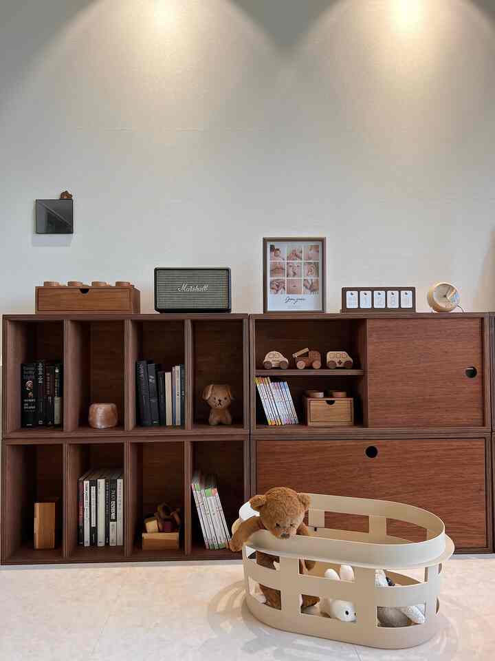 濃い木目調の本棚が並ぶ、すっきりとして赤ちゃんに優しいリビングスペース
