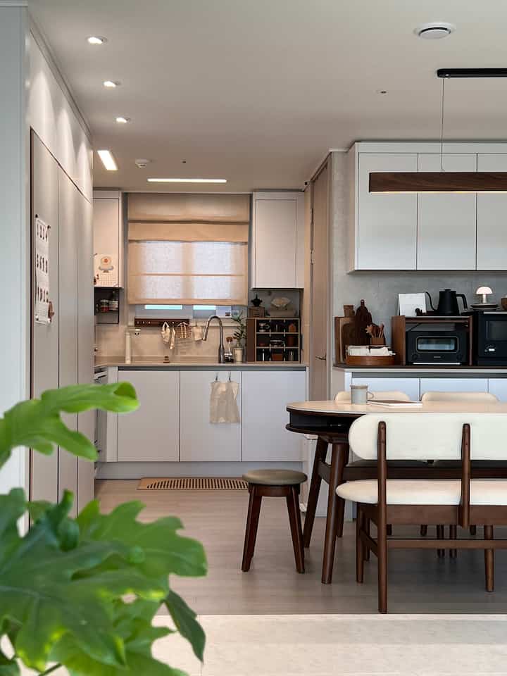 ホワイトとウッド調が調和したモダンなキッチンとダイニングルーム、清潔感のある空間