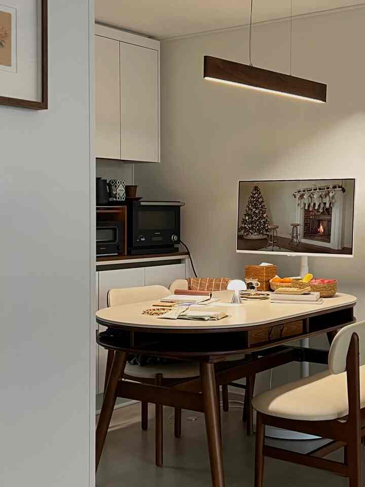 ナチュラルカラーのダイニングルーム、ウォールナットの木製ダイニングテーブルとペンダントライトが温かみのある雰囲気を演出するインテリア