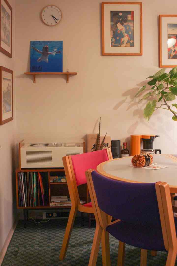 暖かいベージュ色調のダイニングルーム、ヴィンテージ家具と赤青の椅子、ヴィンテージオーディオが配置された雰囲気のあるインテリア