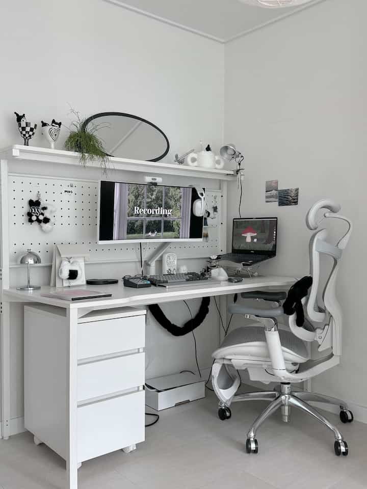 白を基調としたコンパクトなホームオフィス、シンプルなデスクと人間工学に基づいたオフィスチェアが配置されたミニマルな作業空間