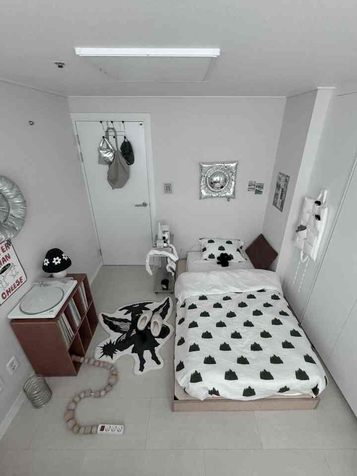 白と木目調の落ち着いた一人暮らし寝室、整ったベッドフレームと清潔感あるシンプルモダンなインテリア