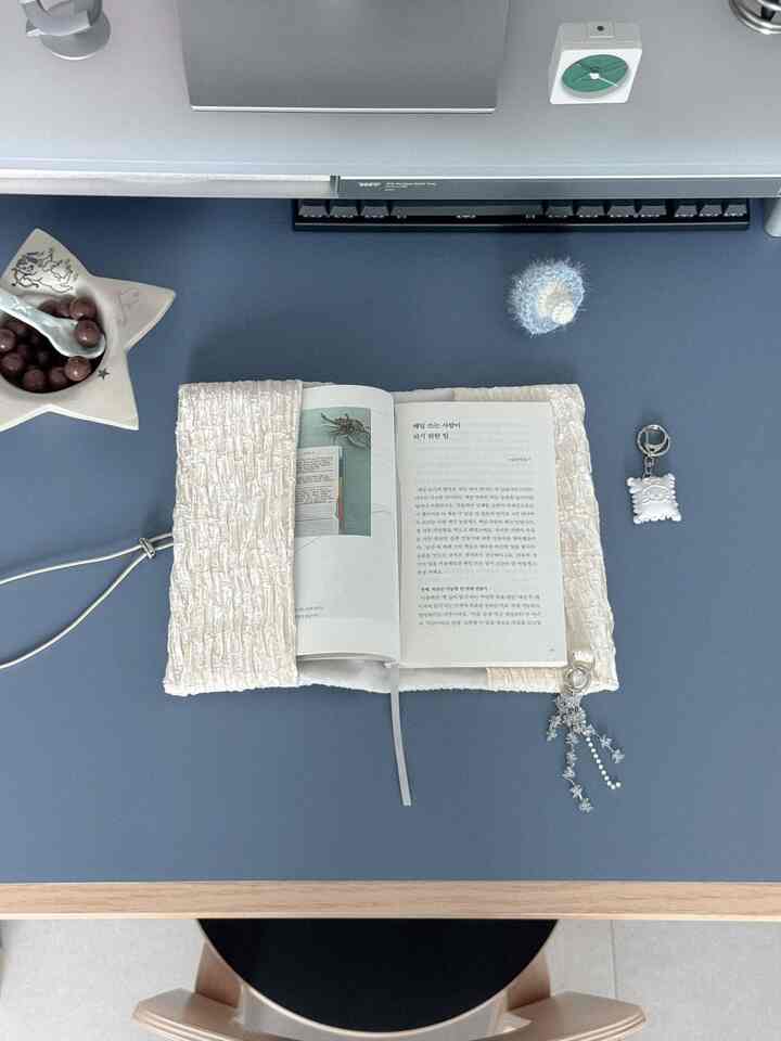 深い青色の机と自然な木目の縁が特徴のミニマルな北欧風ホームオフィス、整然と配置された本とアクセサリー入り