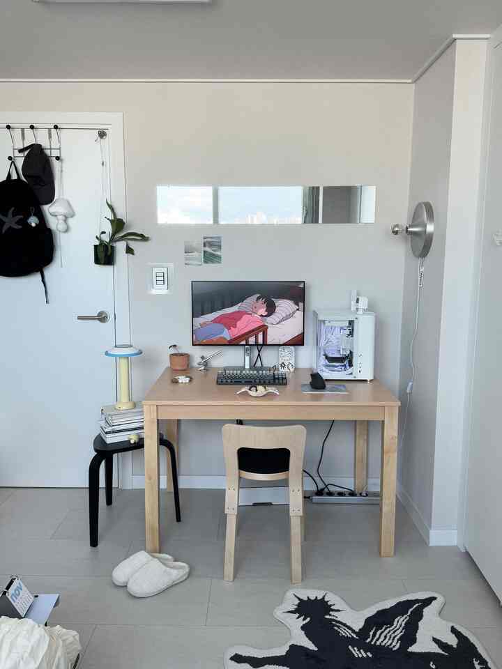 白とナチュラルトーンのホームオフィス、木製デスクと鏡、コンピューター機器が配置されたシンプルモダンなインテリア