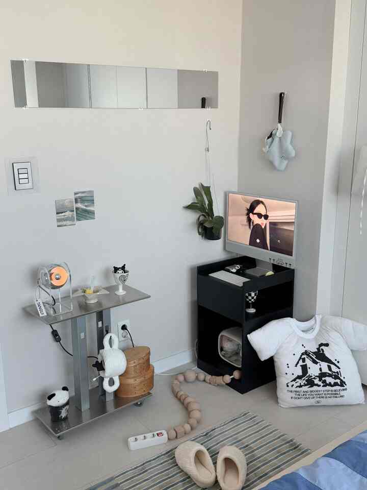 白と黒のトーンのコンパクトなホームオフィス空間、モダンな印象の部屋にアップルのiMac、サイドテーブル、植物が配置されている