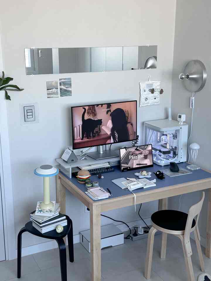 白と木目調の調和が美しいホームオフィス、シルバーの壁照明とモダンな家具が配置された印象的なデスク空間