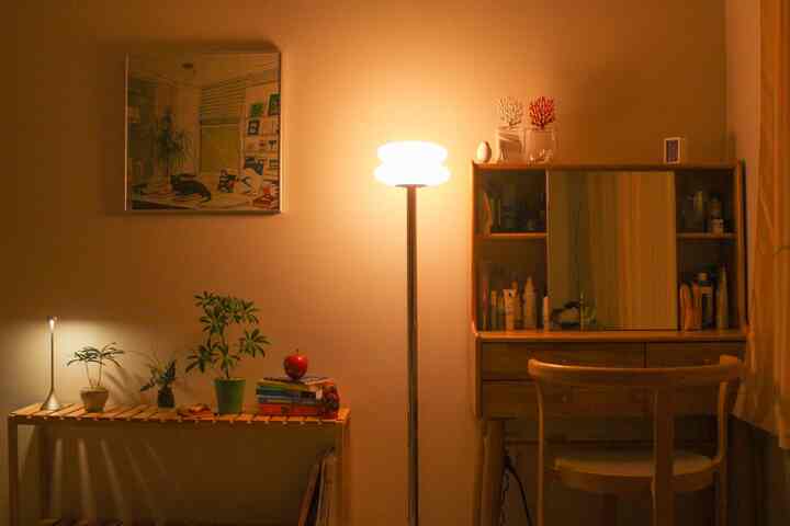 暖かいベージュと木目調のパウダールーム、化粧台と椅子、植物が配置されている居心地の良い空間