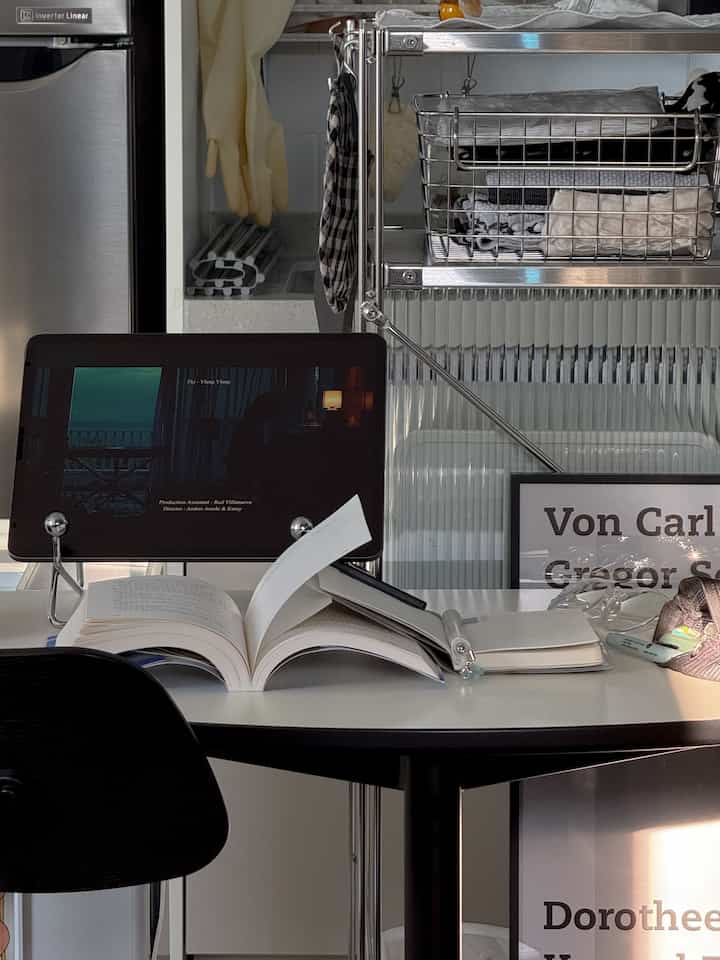 ホワイトとシルバーを基調としたモダンなホームオフィス空間、半円形のテーブルの上にタブレットやデスク用品が置かれたコンパクトなワークスペース