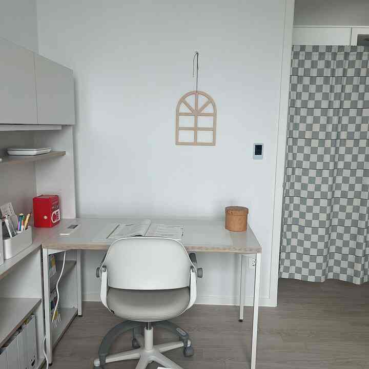 白とグレーの色調の子供用勉強部屋、デスクとオフィスチェアが配置された清潔で整った空間