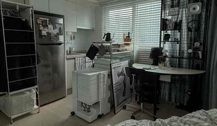 白を基調としたモダンスタイルのワンルーム、キッチンと作業スペースが調和した落ち着く空間