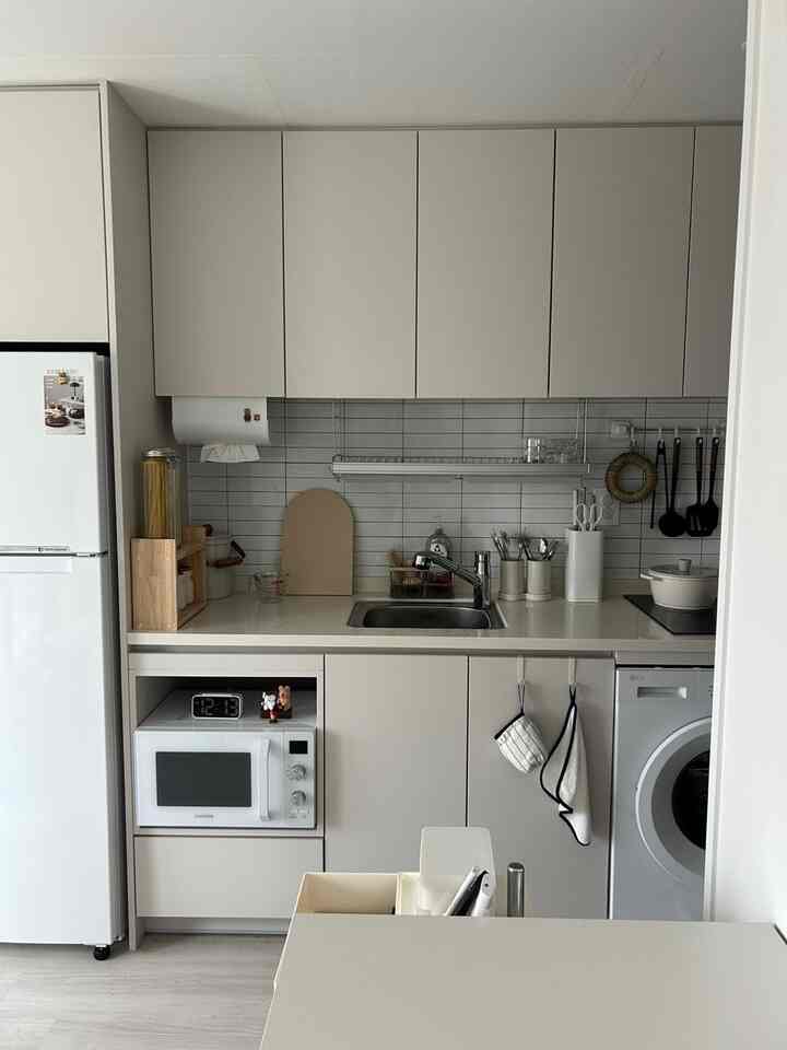 グレーとホワイトの色調の狭いキッチン、収納を工夫した整然としたインテリア