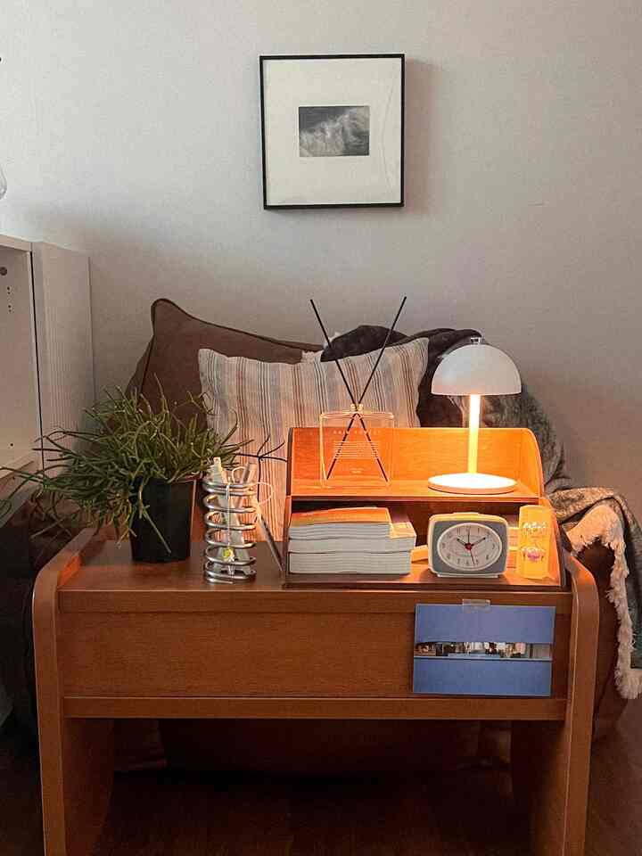 ブラウンとホワイトの色調のリビング、モノフォリオのサイドテーブルとソファ、植物と額縁が調和した雰囲気のあるインテリア