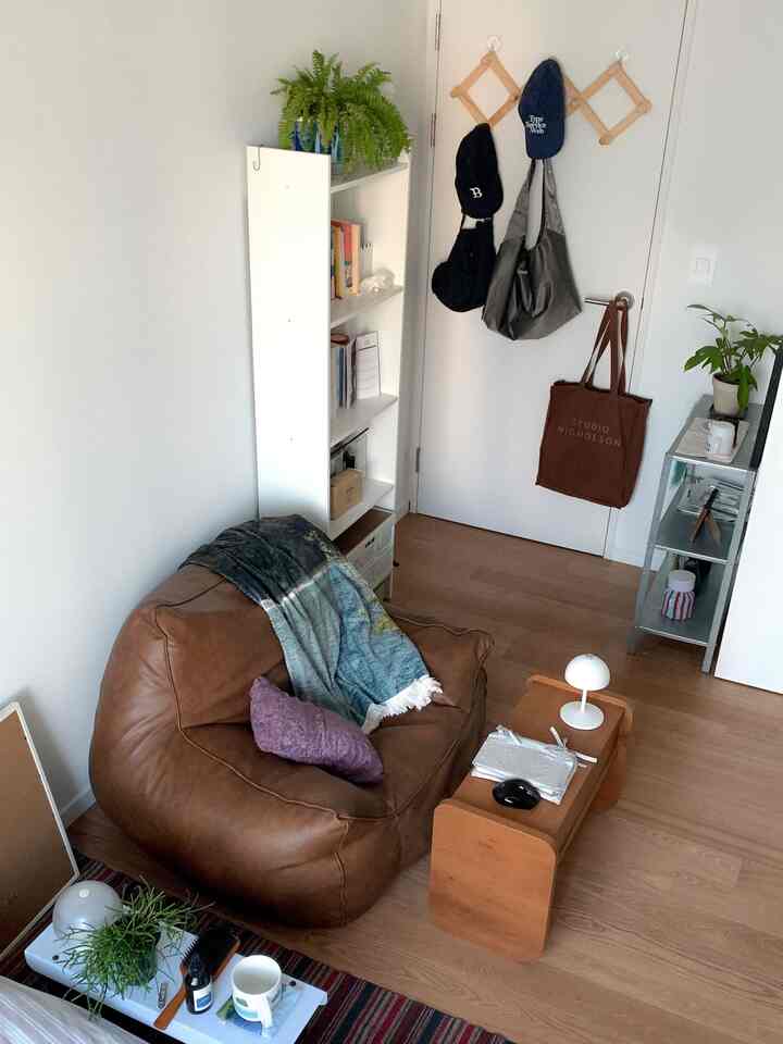 ブラウンとホワイトのトーンの玄関空間、ビーンバッグソファとサイドテーブルが配置されたナチュラルモダンインテリア