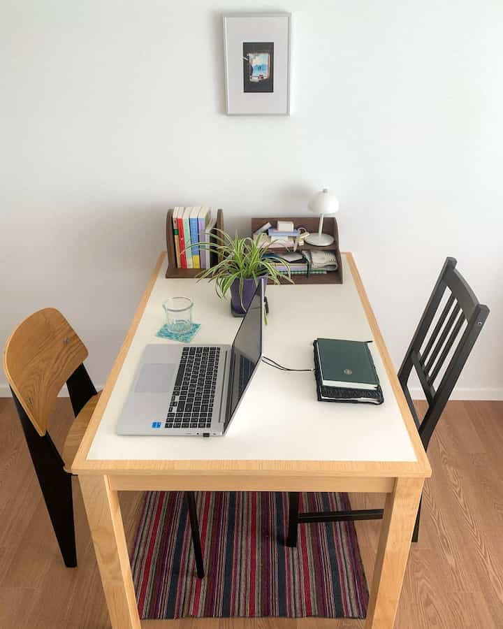 明るい木目調のテーブルと椅子が配置されたシンプルなホームオフィス、清潔で自然な雰囲気のあるインテリア